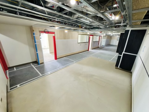 The wider floor plate taking shape — partitions set out with door openings protected as trades move through.