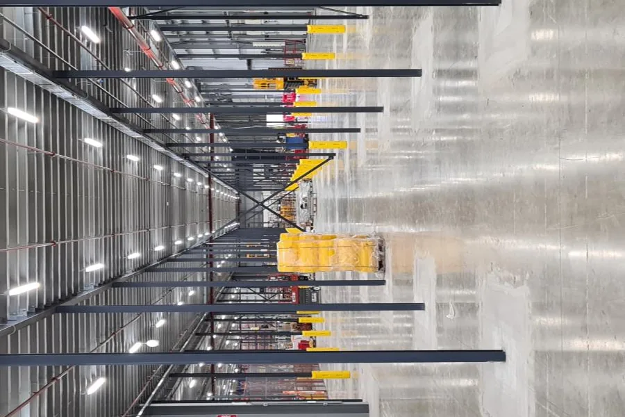 Steel framework and racking running the length of the building
