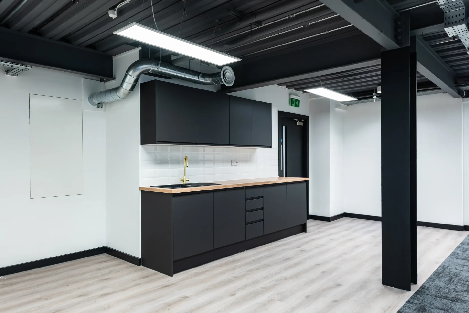 Café point with dark cabinetry, timber worktop and brass tap at the University of Law Bristol