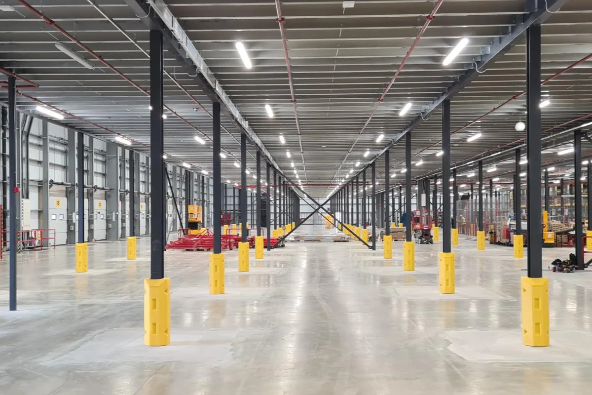 Warehouse floor with column guards and racking beyond